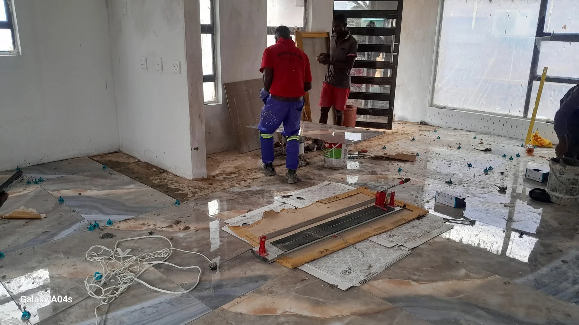 Ceramic floor tiles being installed with precise alignment